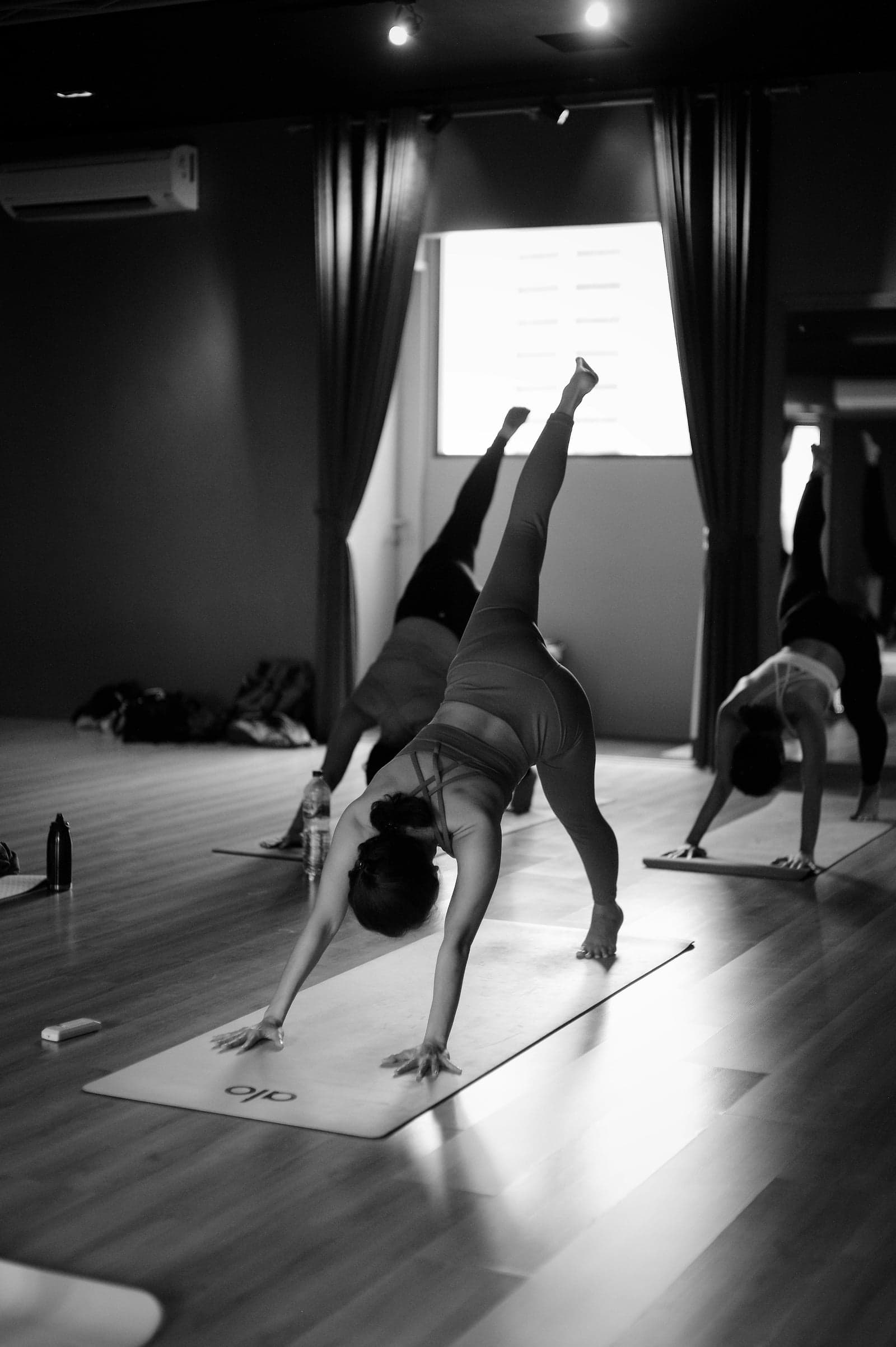 Women in downward dog pose during a vinyasa yoga flow class